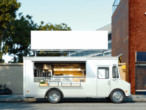 White realistic food truck with detailed interior on cityscpae background with blank canvas billboard or poster above. Takeaway food and drinks. 3d rendering.
